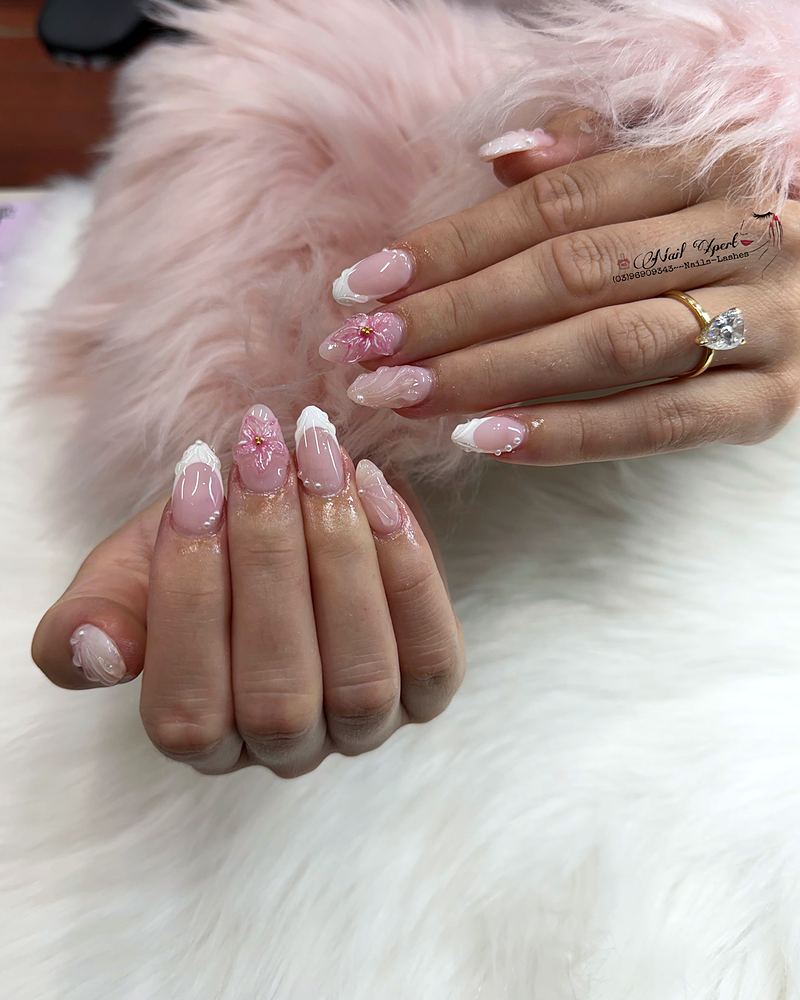 Pink almond nails with white French tips and tiny flowers, resting on soft white and pink fur